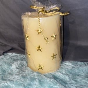 Large Off-white/cream colored candle. With beautiful gold stars